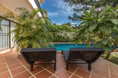 a patio with two chairs and a swimming pool at Villa Belloro Bang Tao 3BR East Residence in Ban Pak Lak