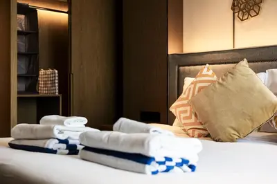 a hotel room with a bed with towels on it at Suite Aura 1BR PoolsGyms Shuttle to Nai Harn in Rawai Beach