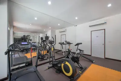 a gym with several treadmills and exercise bikes at ARIA Condo 1BR Pool View NBC Nai Harn in Phuket Town