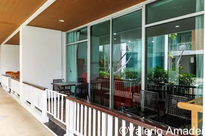 a balcony of a building with tables and chairs at OMNIAPHUKET - Pool access 3 bedrooms apartment in Patong Beach