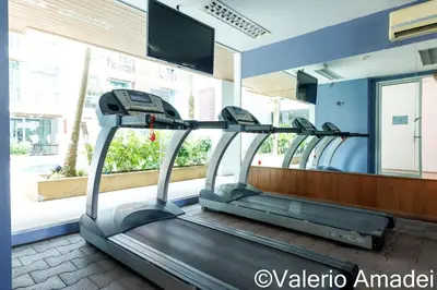 a treadmill in a gym with a mirror at OMNIAPHUKET - Pool access 3 bedrooms apartment in Patong Beach