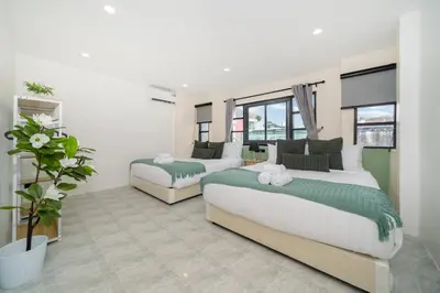 a bedroom with two beds and a plant in it at Wink 3 Patong Beach Phuket sleep 8 in Patong Beach