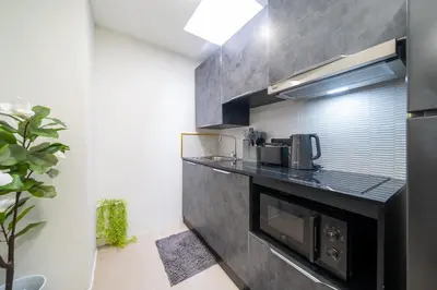 a kitchen with a black counter and a microwave at Wink 3 Patong Beach Phuket sleep 8 in Patong Beach