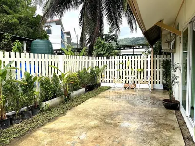 a white fence with plants in front of a house at Home Hug local stay Bangtao in Bang Tao Beach