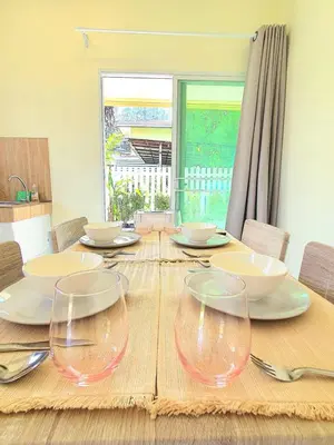 a wooden table with wine glasses on top of it at Home Hug local stay Bangtao in Bang Tao Beach
