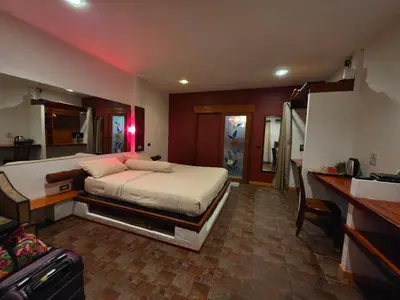 a bedroom with a large bed and a kitchen at Leon Oasis Nai Harn in Rawai Beach