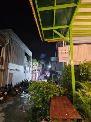 a street at night with a bench next to a building at Little Green House in Ao Nang Beach