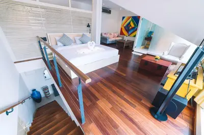 a living room with a bed and a staircase at Patong Condotel Penthouse 2 bedroom in Patong Beach