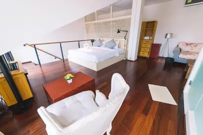 a bedroom with a bed and two chairs and a table at Patong Condotel Penthouse 2 bedroom in Patong Beach