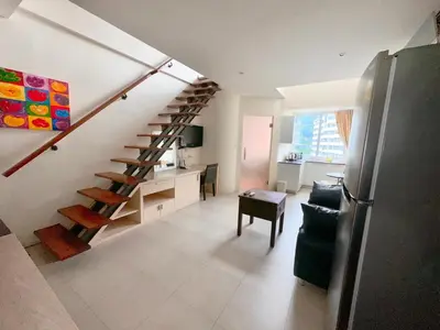 a kitchen and a living room with a staircase at Patong Penthouse 1 bedroom in Patong Beach
