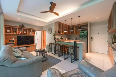 a living room with a couch and a kitchen at Cozy Apartment with Pools Near the Beach in Kamala Beach
