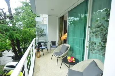 a balcony of a house with chairs and a table at Cozy Retreat Near Beach and Pools in Kamala Beach
