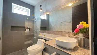 a bathroom with a white sink and a toilet at Ban Khuendee Pool Villa in Kathu