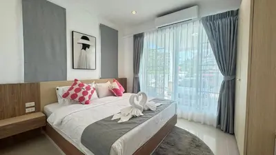 a bedroom with a bed and a large window at Ban Khuendee Pool Villa in Kathu