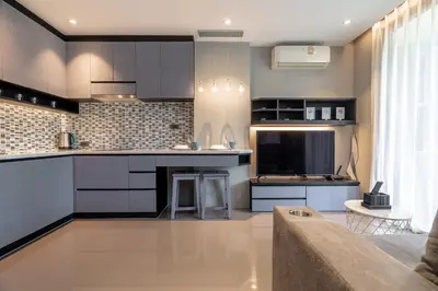 a kitchen with black cabinets and a counter top at Suite Ruse 1BR Rooftop Pool ViewCitygate Kamala in Kamala Beach