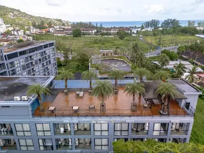 an aerial view of a building with palm trees at Suite Ruse 1BR Rooftop Pool ViewCitygate Kamala in Kamala Beach