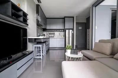 a living room with a couch and a kitchen at Luxury 1BR Resort Retreat by IBG Property P514 in Kamala Beach