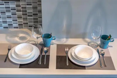 a table with plates and forks and wine glasses at Luxury 1BR Resort Retreat by IBG Property P514 in Kamala Beach