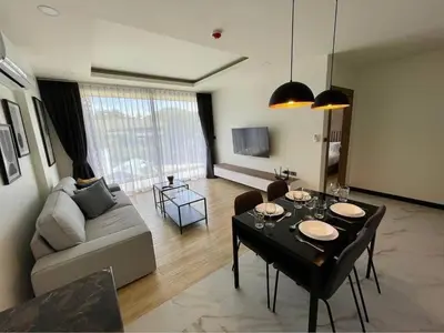 a living room with a couch and a table with glasses on it at Sea Breeze 2 Bedrooms Rawai Naiharn Beach in Rawai Beach
