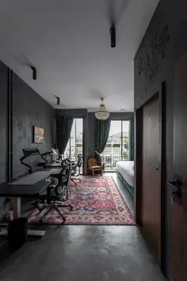 a room with desks and a bedroom with a bed at Boss Level Gaming Hotel in Rawai Beach