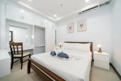 a bedroom with a bed with a desk and a chair at Apartment with jacuzzi - Patong Tower by lofty in Patong Beach