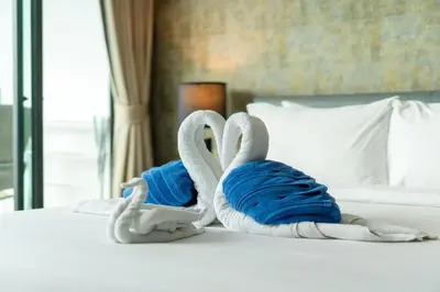 two towels shaped like swans sitting on a bed at Private apartment at Twin Sands near Merlin beach in Patong Beach