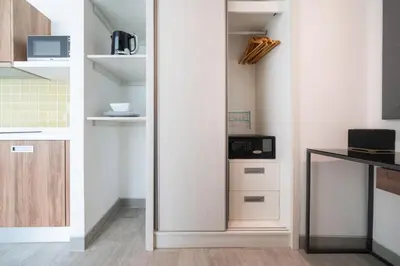 a kitchen with a closet with a microwave in it at Private apartment at Twin Sands near Merlin beach in Patong Beach