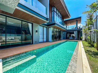 a house with a swimming pool in front of a house at The Ozone Luxury Villas Phuket in Laguna Phuket