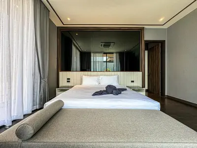 a bedroom with a large white bed with a large mirror at The Ozone Luxury Villas Phuket in Laguna Phuket