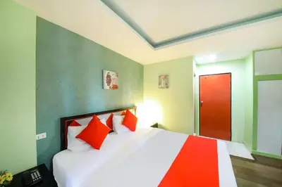 a bedroom with a bed with orange pillows and a red door at Chilli House Residence in Patong Beach