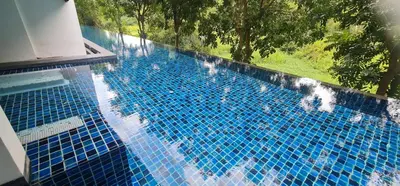 a swimming pool with blue tiles on it at Modern studio in Boat Avenue close to the beach in Bang Tao Beach