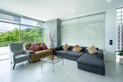 a living room with two couches and a table at Sirirat Sea-view Villa in Patong Beach