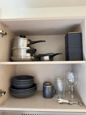 a shelf with pots and pans and plates and glasses at Poolside Paradise, Nice pool view in Kathu