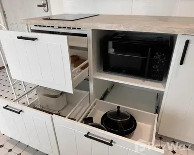 a kitchen with white cabinets and a black microwave at VE1 Halo 2-bedroom ВатСaп66935B2I976 in Nai Yang Beach