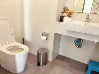 a bathroom with a white toilet and a sink at \u65e0\u5c18\u522b\u9662 Pure Haven Villa in Ban Phru Champa