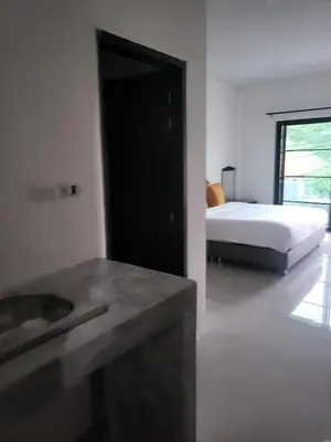 a bedroom with a bed and a sink in it at KK Apartment BangJo, Phuket in Koh Lone