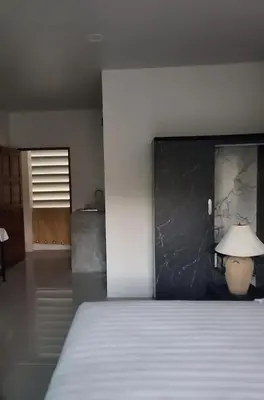 a bedroom with a white bed and a black wall at KK Apartment BangJo, Phuket in Koh Lone