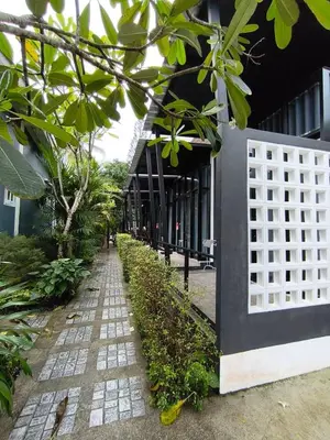 a building with a white gate next to a sidewalk at Finlay Cottage Aonang in Ban Khlong Haeng
