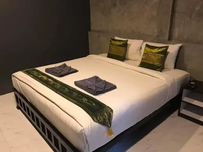 a bedroom with a large bed with two towels on it at Finlay Cottage Aonang in Ban Khlong Haeng