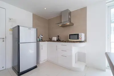 a white kitchen with a refrigerator and a microwave at Kata Ocean View I05 in Karon Beach