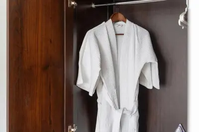 a white robe hanging on a rack in a bathroom at Kata Ocean View I05 in Karon Beach