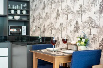 a kitchen with a table with two glasses of wine at \u65b0\u623f\u7279\u60e0 \u82ad\u4e1cTheDeck10\u7cbe\u88c5\u4e00\u5367\u5ba4\u516c\u5bd3 \u8fd1\u82ad\u4e1c\u6d77\u6ee9Bangla\u6c5f\u897f\u51b7 in Patong Beach