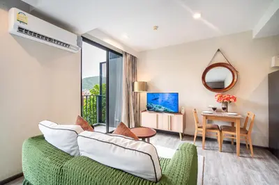 a living room with a green couch and a table at \u82ad\u4e1cTheDeck220\u7cbe\u88c5\u4e00\u5367\u5ba4\u516c\u5bd3 \u8fd1\u82ad\u4e1c\u6d77\u6ee9Bangla\u6c5f\u897f\u51b7 in Patong Beach