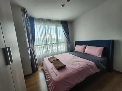 a bedroom with a bed with a blue headboard and a window at cen 1 bed room859 in Ban Rangeng