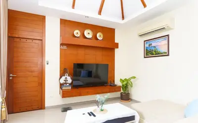 a living room with a tv and a wooden wall at Villa with Private Pool in Rawai in Rawai Beach
