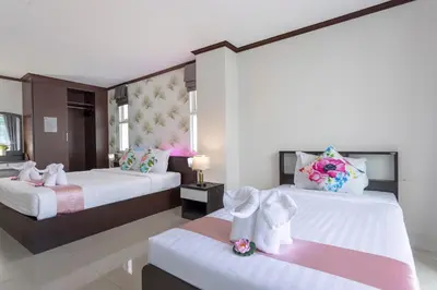 a bedroom with two beds with towels on them at The Chic Patong Hotel in Patong Beach