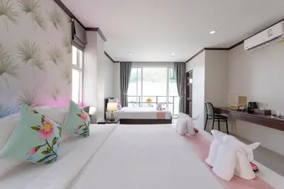 a bedroom with a large bed with stuffed animals on it at The Chic Patong Hotel in Patong Beach