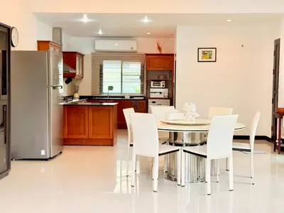 a kitchen and dining room with a table and chairs at BlueElephant Villa NaiHarn in Rawai Beach