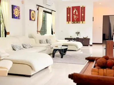 a living room with white couches and a table at BlueElephant Villa NaiHarn in Rawai Beach