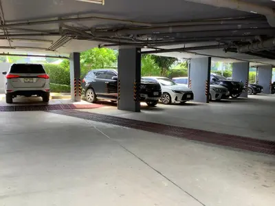 a parking lot with several cars parked in it at Superb Apartment! 5 Mins to the Beach in Surin Beach